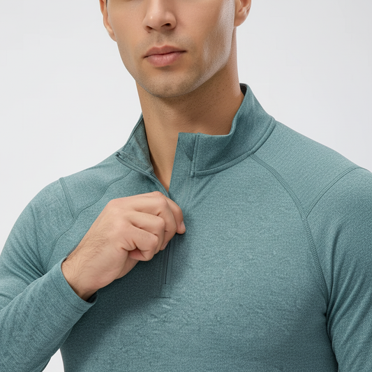 Erkek 1/4 fermuarlı antrenman üstü; yüksek yaka ve fermuar yapısını gösteren yakın plan, dikiş hatları ve fit görünüm.